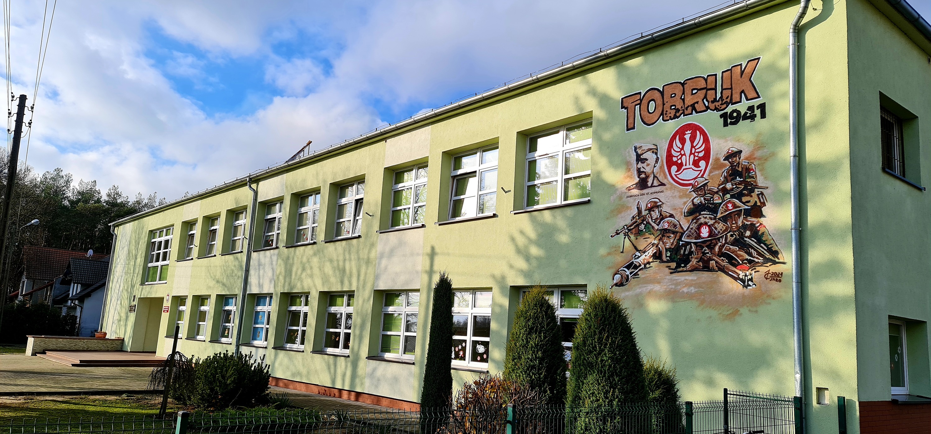 Budynek szkoły z muralem Tobruku